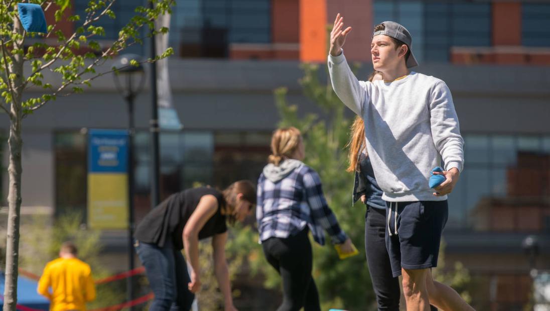 Student playing cornhole