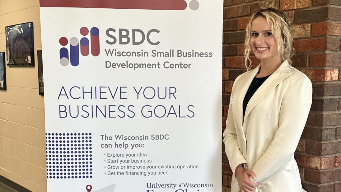 Marketing student, Kaitlyn Riehle, standing next to sign for internship with UWEC