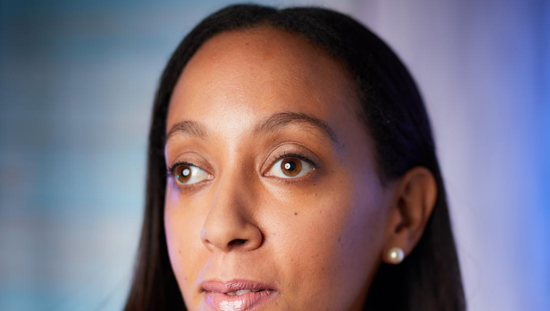 A woman poses to a camera in profile.
