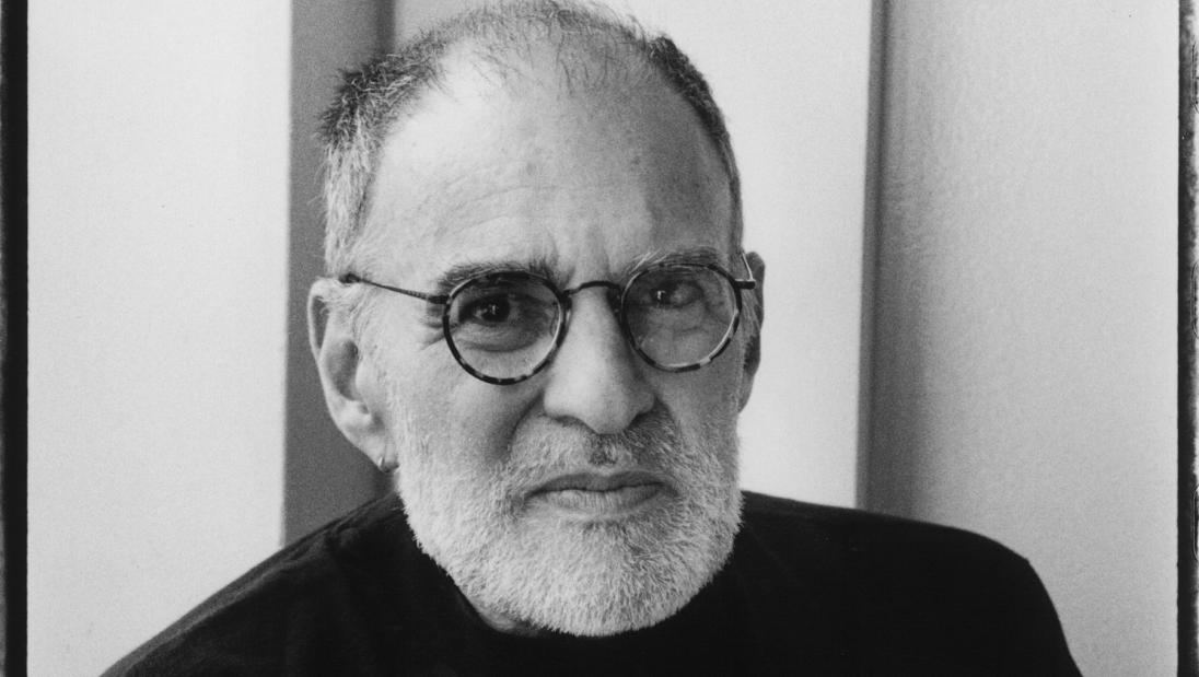 A seated man smiles for the camera.