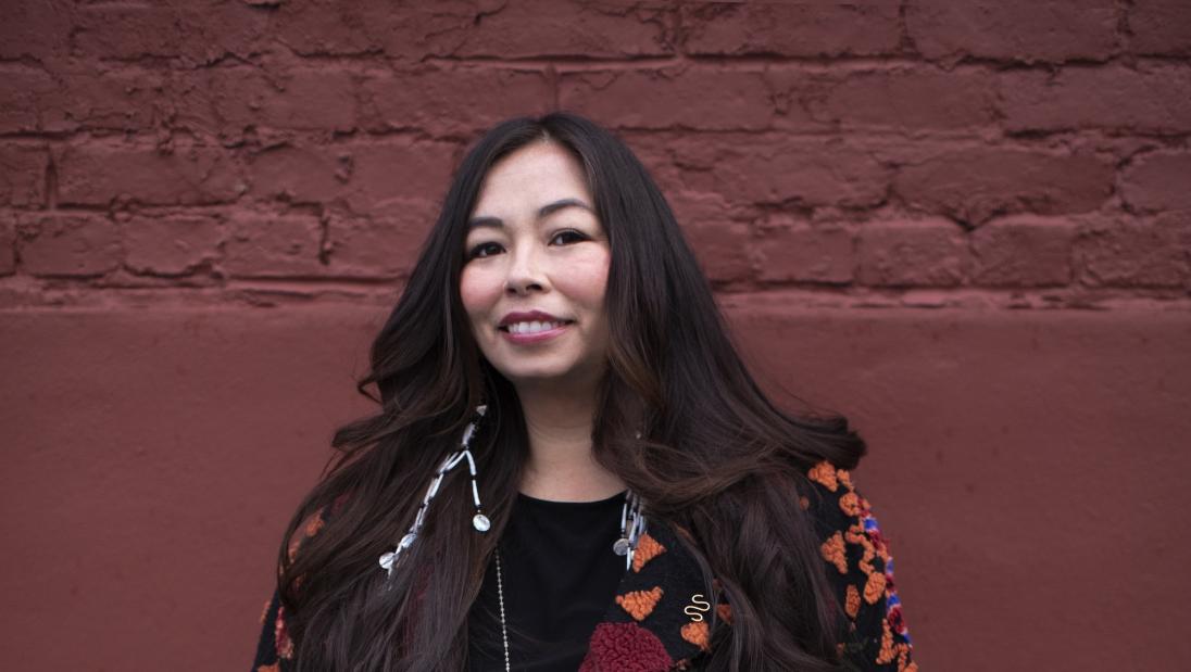 A woman smiles facing the camera.