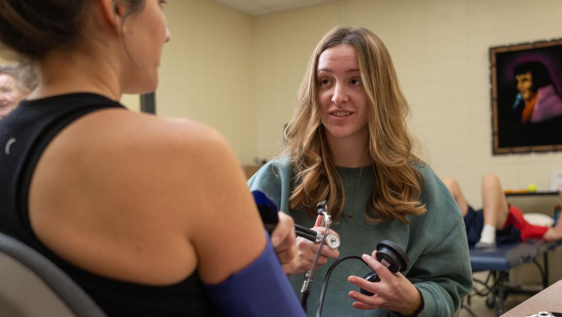 student doing a blood pressure check on a community client 