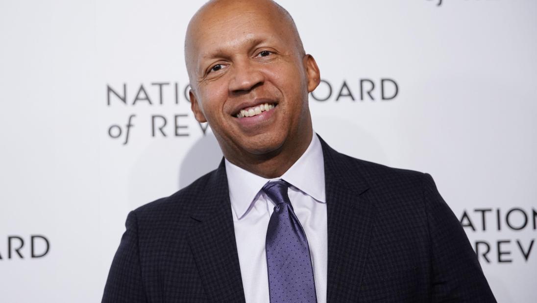 Black man smiles for the camera.