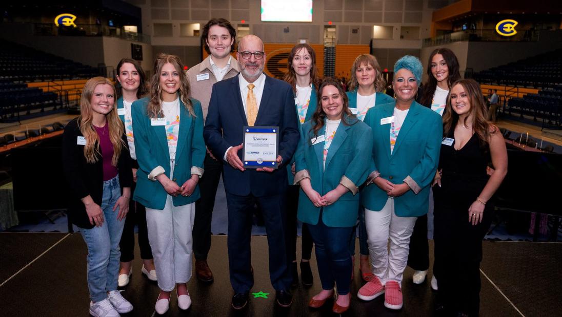 Marketing student, Haley Shaske, standing with EC Chamber of Commerce for the Sonnentag opening during her internship.