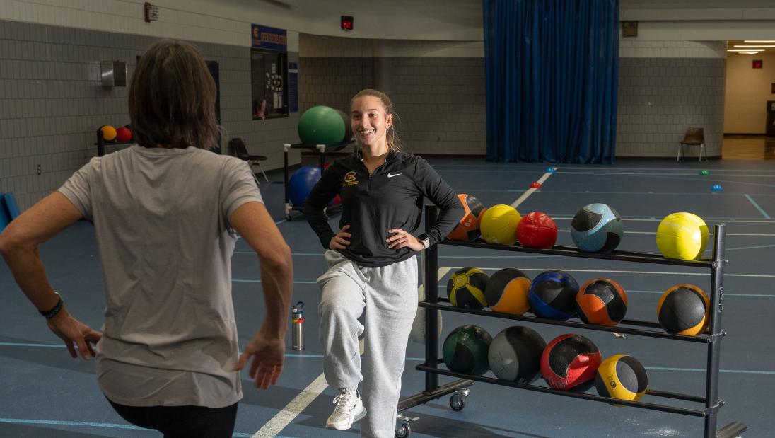 Student stands on one foot to demonstrate balance testing at a community fitness event.