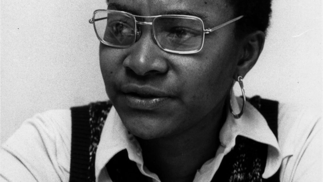 A Black woman looks to the side in a portrait.