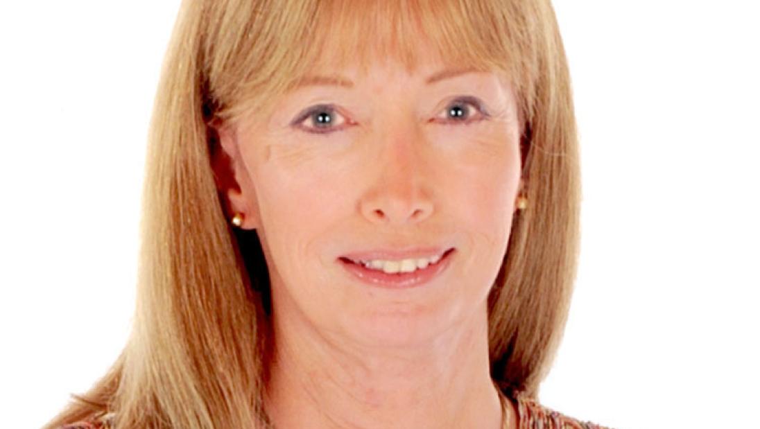A white woman smiles in a portrait.