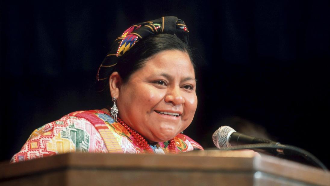 A woman smiles at a lecturn.