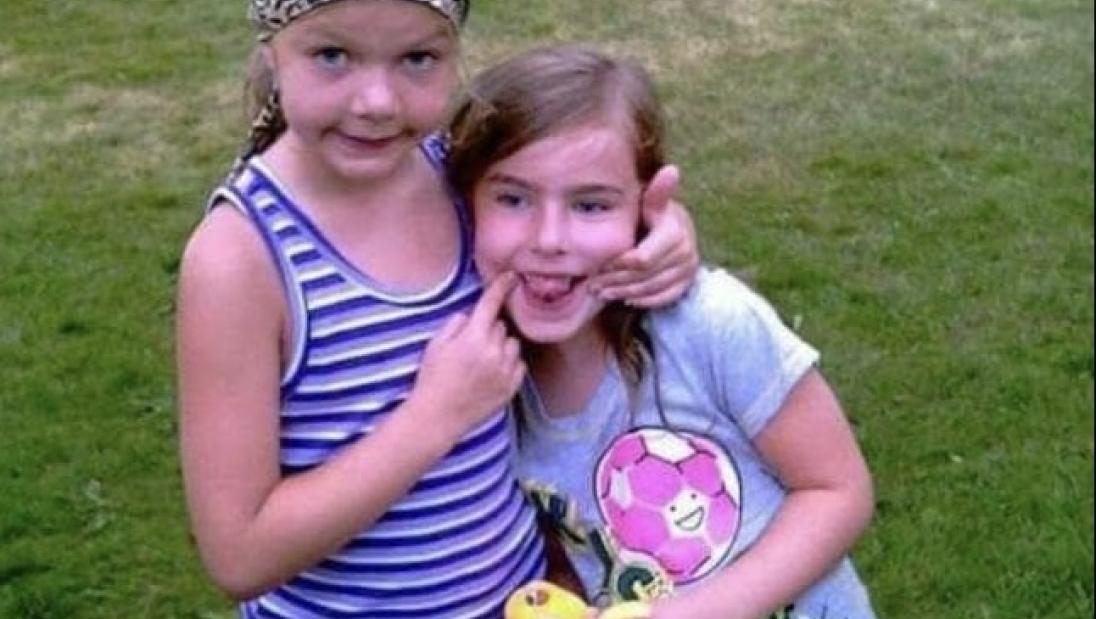 Childhood Hannah Schindler poses with friend at a park