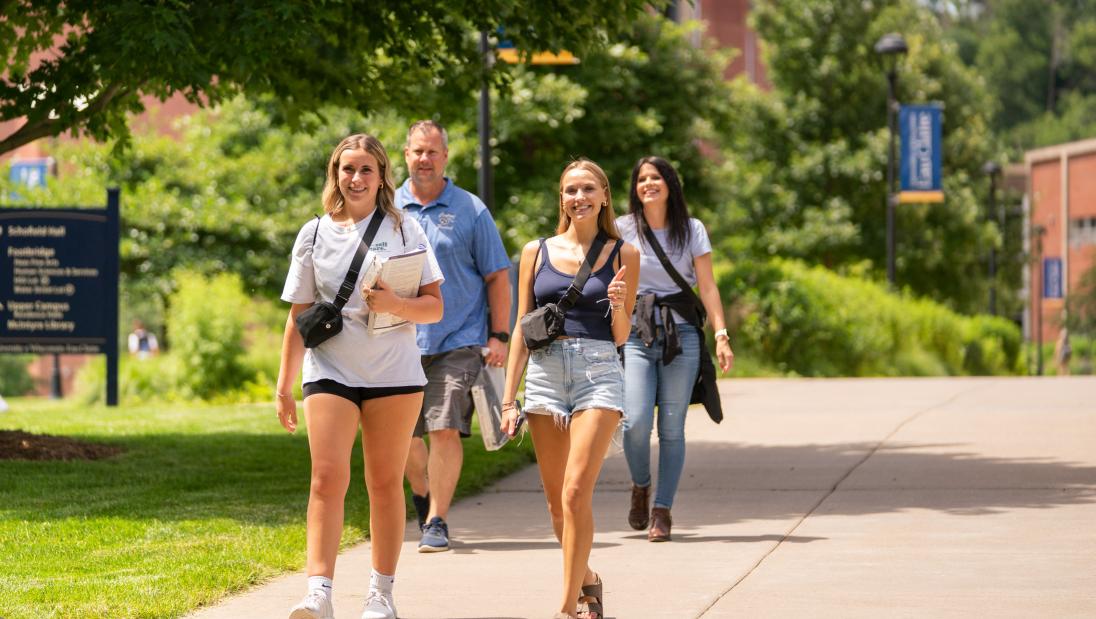 students smiling with parents in the background