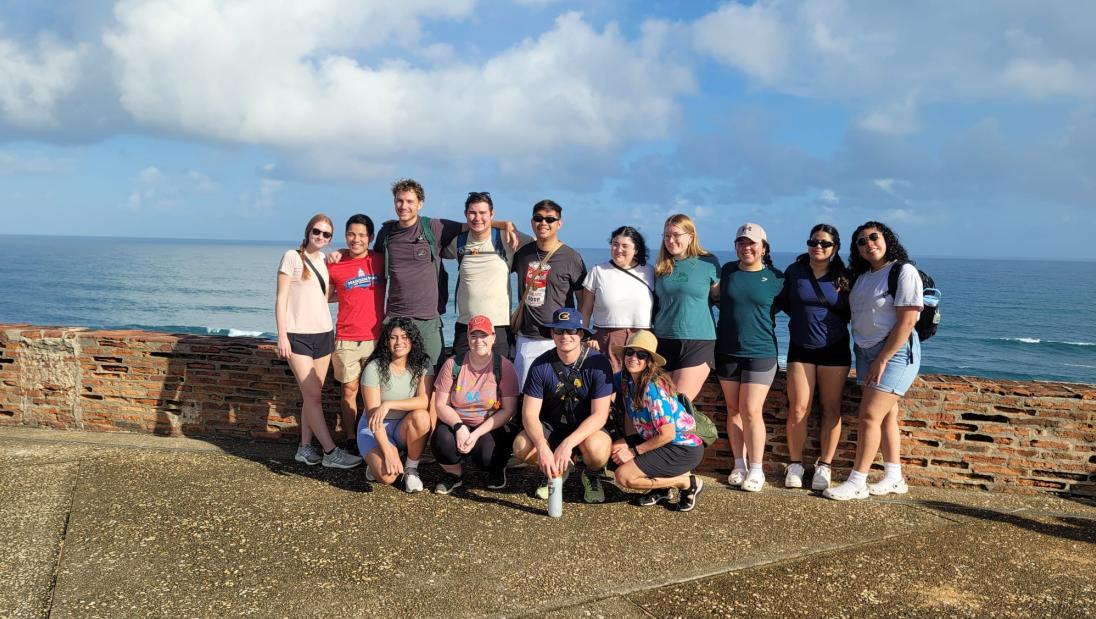 Group photo of the immersion participants in front of the ocean
