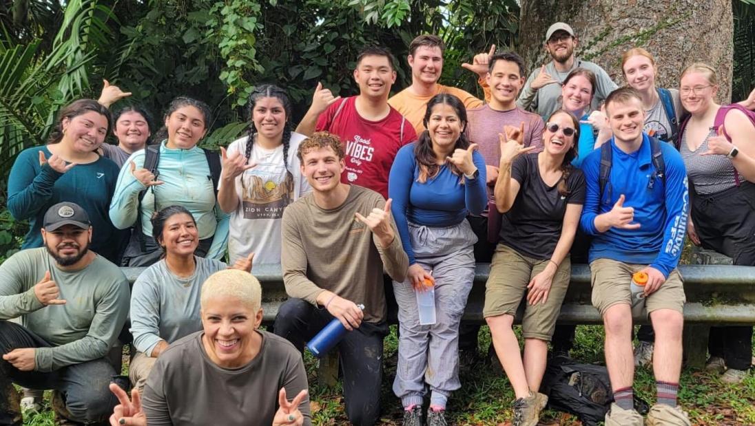 Immersion participants smiling for a group photo after working in the rain forest.