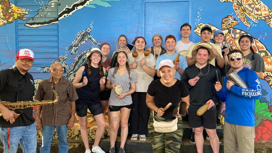 Immersion participants celebrating the holidays with community hosts and musical instruments 