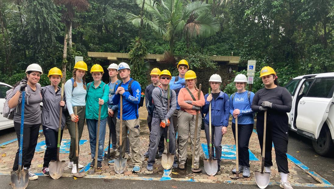 Students looking serious with tools after a long day working in the rain forest