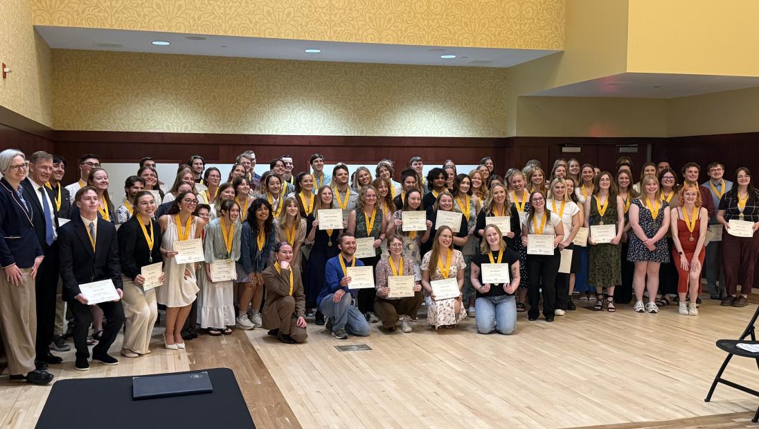Class of 2026 Cosby Honors College Graduates pose for a picture at the graduate reception, wearing honors medallions and holding honors certificates