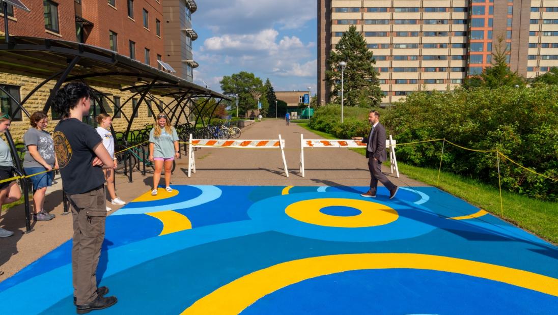 Chancellor Edwin Martini tours sidewalk mural outside The Suites