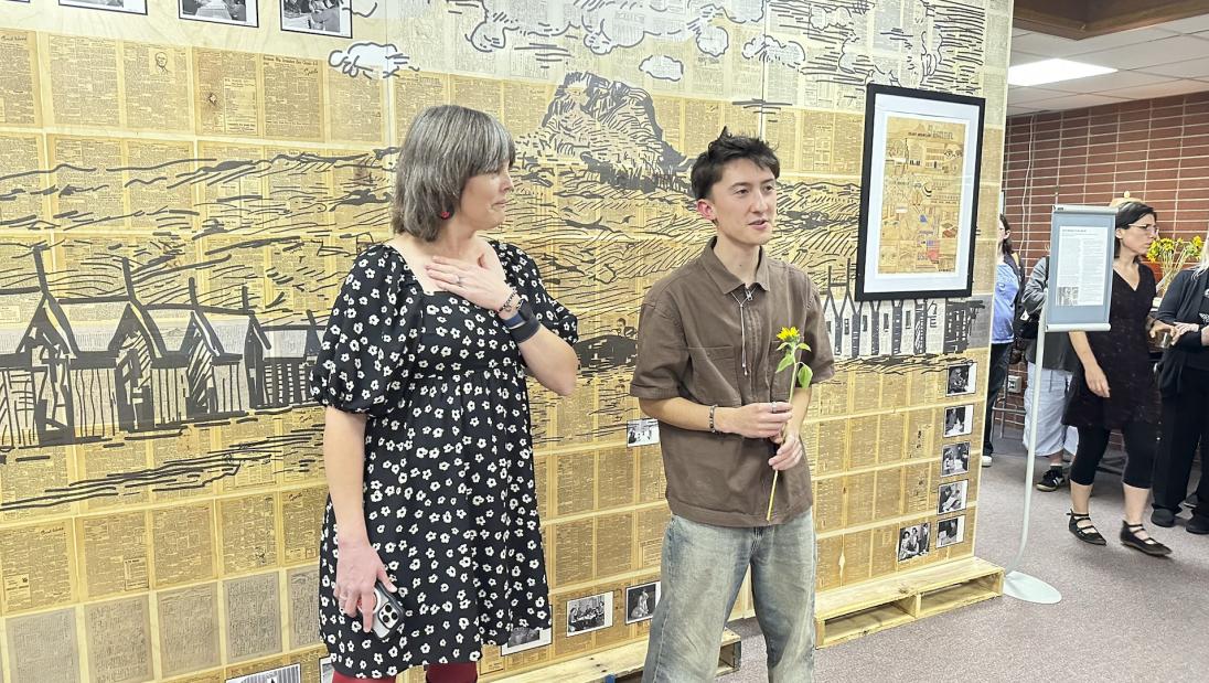 Kai Hirata speaks at "The Small and the Mighty: Chippewa Valley" exhibit opening reception as Anna Zook looks on