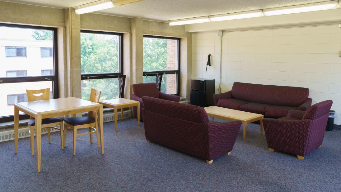 A common space with couches for lounging and tables for studying.