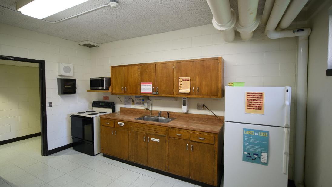 A kitchen with a fridge, oven, sink, microwave, and counter space.