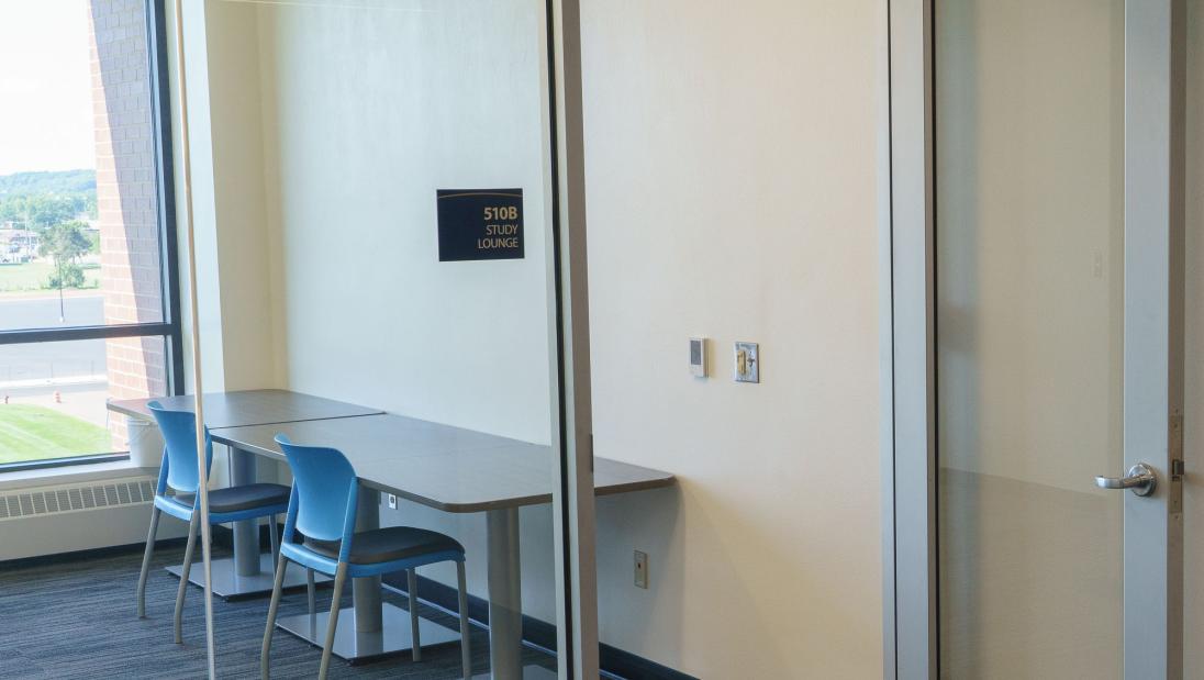 A study lounge with desk space, a glass wall and large windows