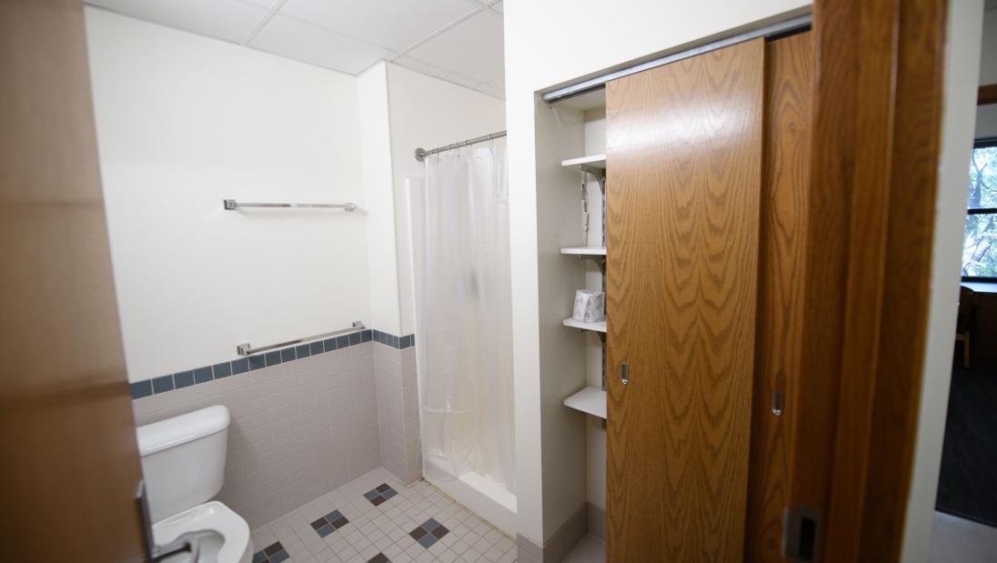 Bathroom space in a Chancellors Hall apartment with toilet, shower, and closet.
