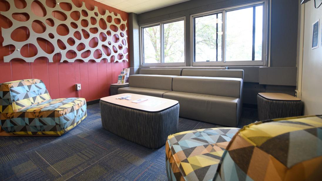 Horan Hall lobby with colorful chairs, a couch, and side tables.