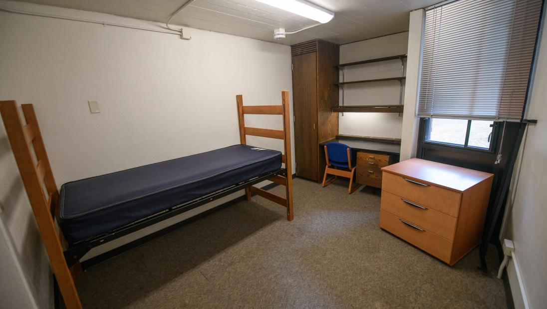 Single room at Priory Hall with a twin Xl bed, desk, chair and dresser