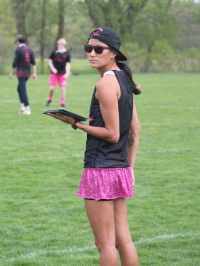 Nora Mitchell holding a clipboard on a sport field.