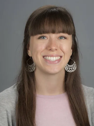 Headshot of a white woman with long brown hair.