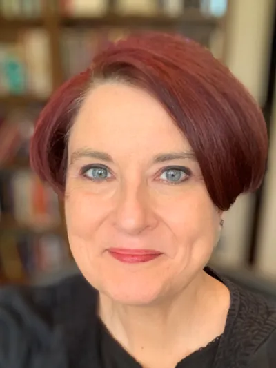 Woman with red hair and green eyes smiling