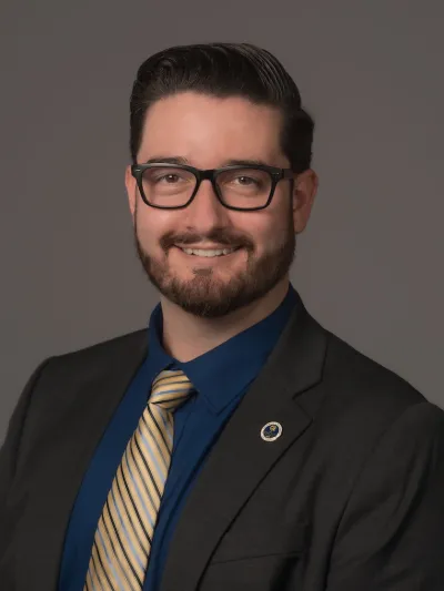 Jake Wrasse pictured wearing a suit and a blue and gold tie