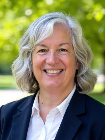Headshot of Dean Kristen Abbott-Anderson wearing white blouse and navy blue jacket in an outdoor setting