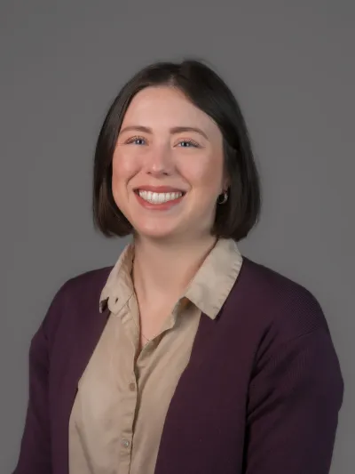 Joann headshot wearing purple cardigan and button up shirt