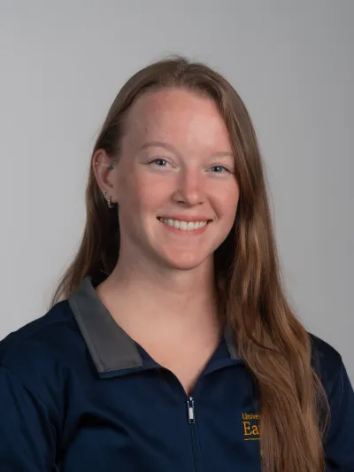 Image shows a woman in a Housing and Residence Life quarter zip. 