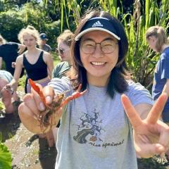 Yangguang Chen holding a shrimp up to the camera.