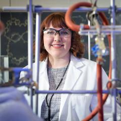 Muriel Metko in a chemistry lab smiling at the camera