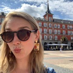 female student in sunglasses in front of a building in Madrid 
