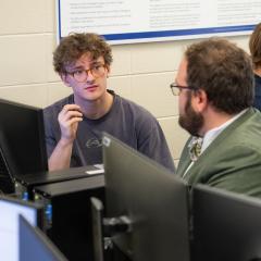 Student and professor discussing in the computer room