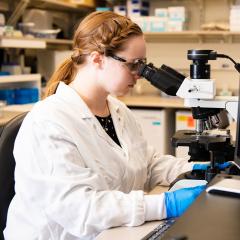 student at a microscope