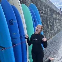 Allison poses with a row of surfboards.