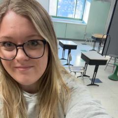 A selfie Sarah in front of her classroom.