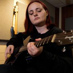 Irie Ulrich plays the guitar in UWEC's Recording Studio.
