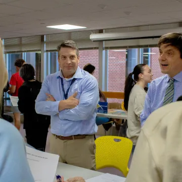 Two professors talk with students.