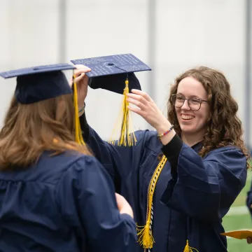 girls adjusting caps on graduation day 