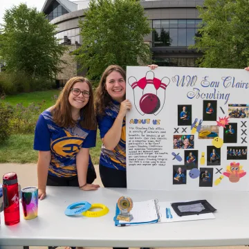 Three students hold up a sign about UW-Eau Claire's Bowling Student Org at the Annual Student Org Fest.