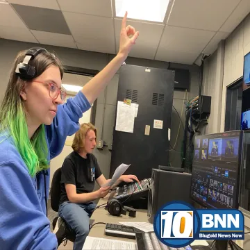 The director of BNN cuing the on-air talent