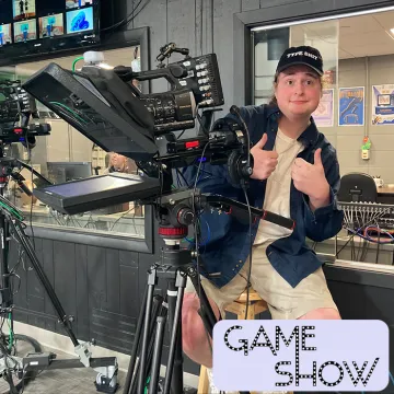 A student working at a camera during an episode of Gameshow
