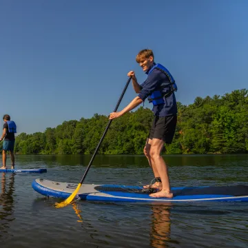 Two students paddleboard on the Chippewa River.