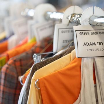 rack of costumes, labeled for actors names 