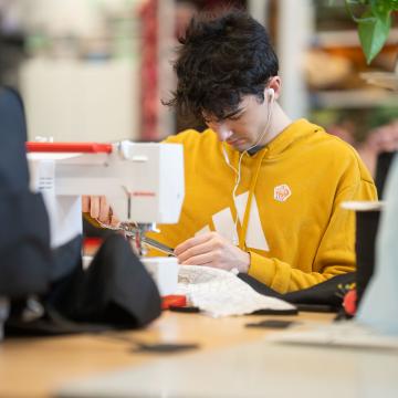 student sewing in costume design room at Pablo